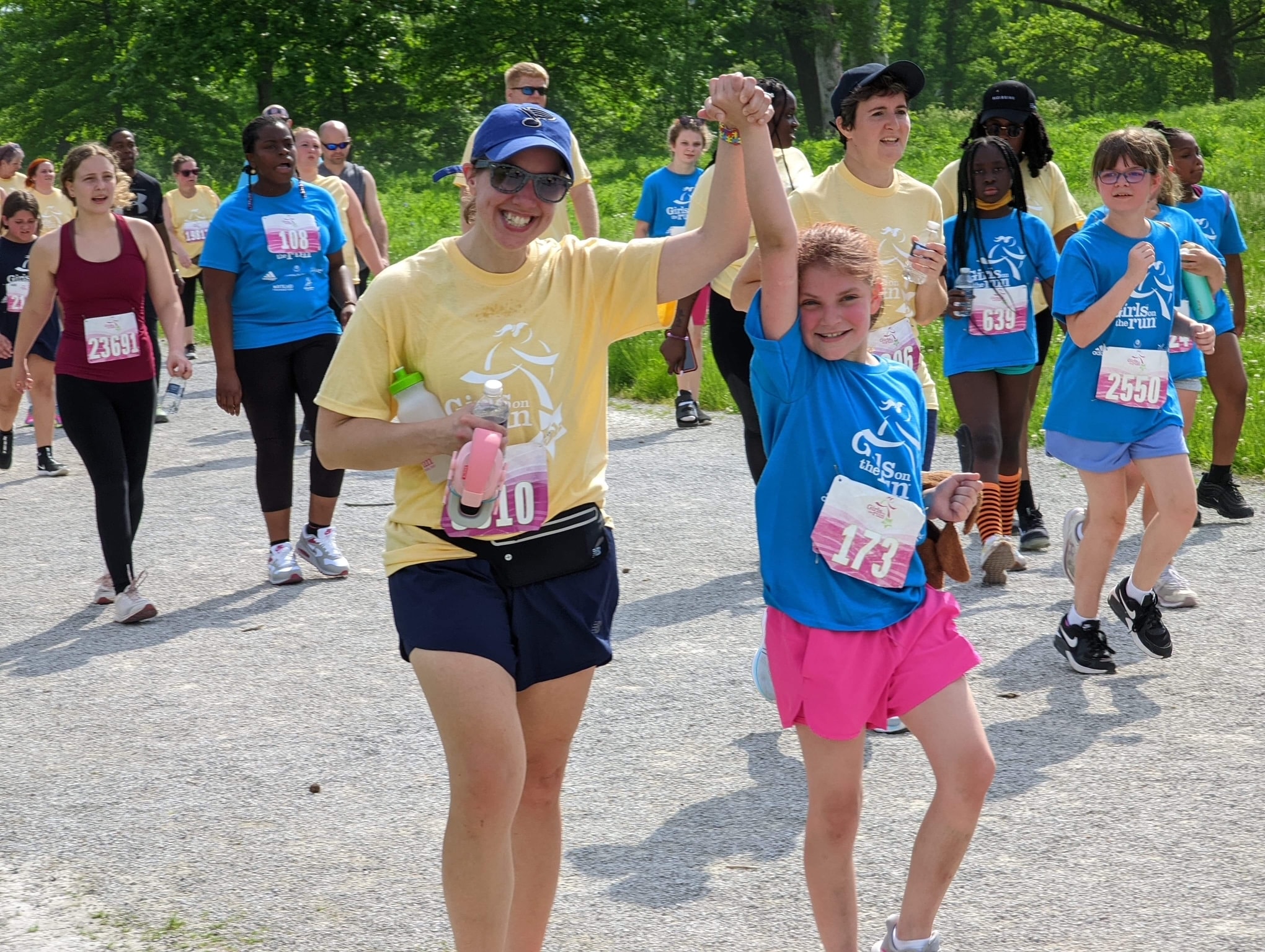 A Girls on the Run participant smiles while holding a bouquet of yellow flowers 